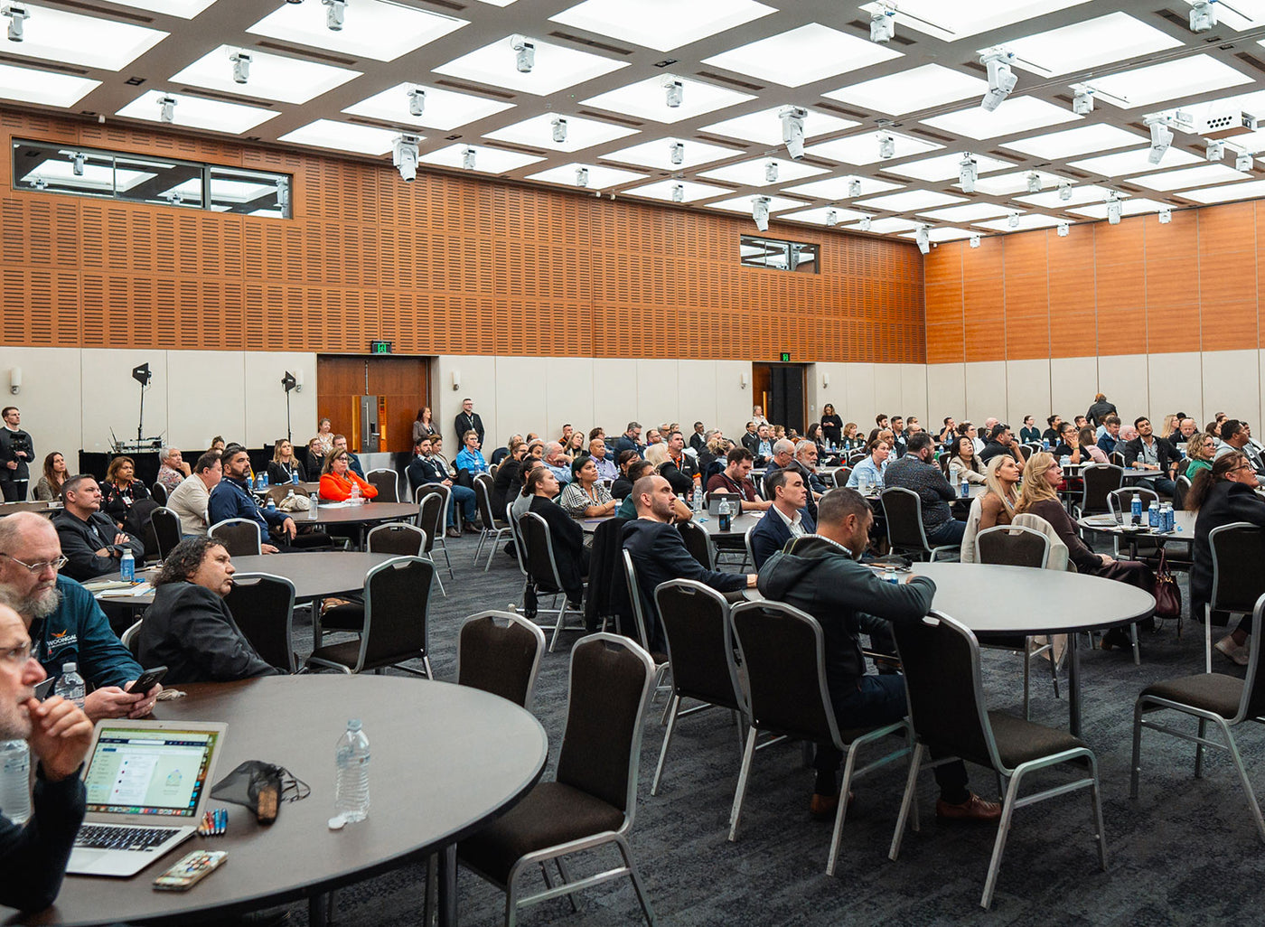 A high-angle landscape photograph of corporate delegates, resources majors, and First Nations innovators participating in an active plenary session at a national AEMEE forum.