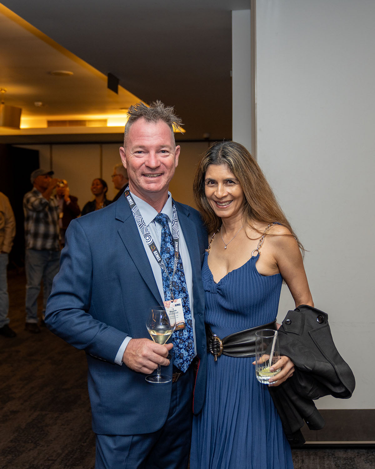 A male and female delegate smiling together near the main function room entrance during the gala celebrations.