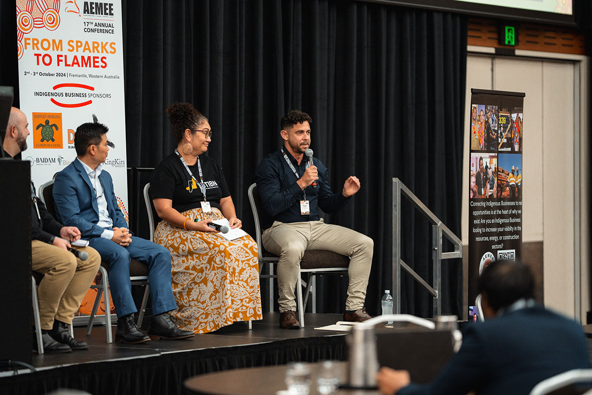 Four seated panel speakers on stage sharing insights into commercial opportunities and structural equity within the Indigenous business resources sector.