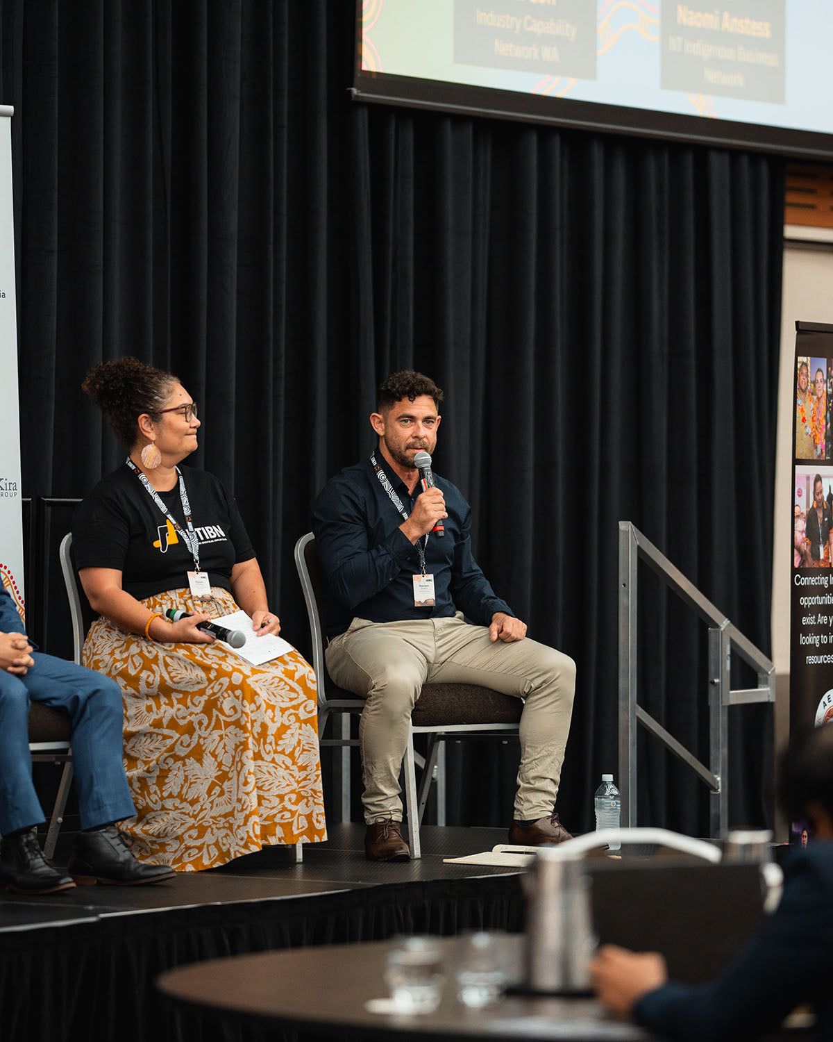 Two panelists addressing the main hall audience during an interactive technical stream discussion at the annual national AEMEE conference.