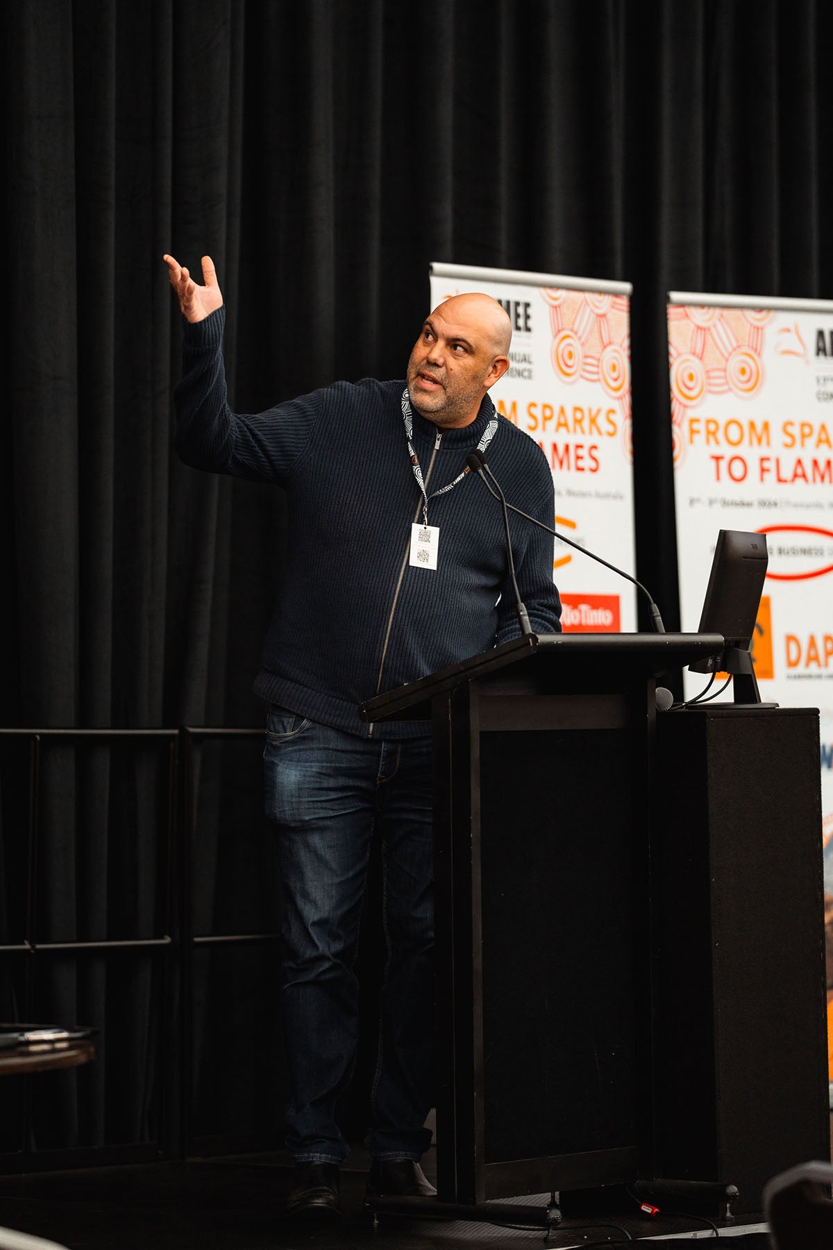 Michael Grundon speaking at the podium during the “Creating Unity Between Corporations & Country” presentation.