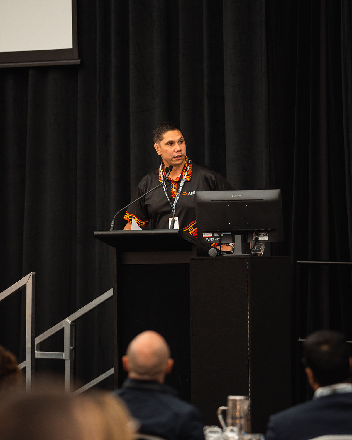 Jyi Lawton, AEMEE CEO presenting at the podium during Session 2 of the 2024 AEMEE Annual Conference in Fremantle, WA.