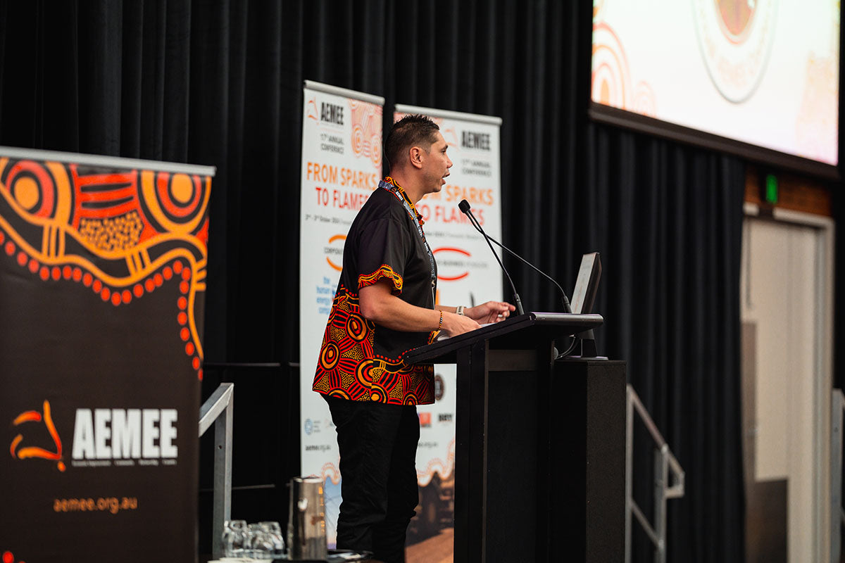 AEMEE CEO Jyi Lawton speaking at the podium during the 2024 AEMEE Annual Conference in Fremantle, WA.