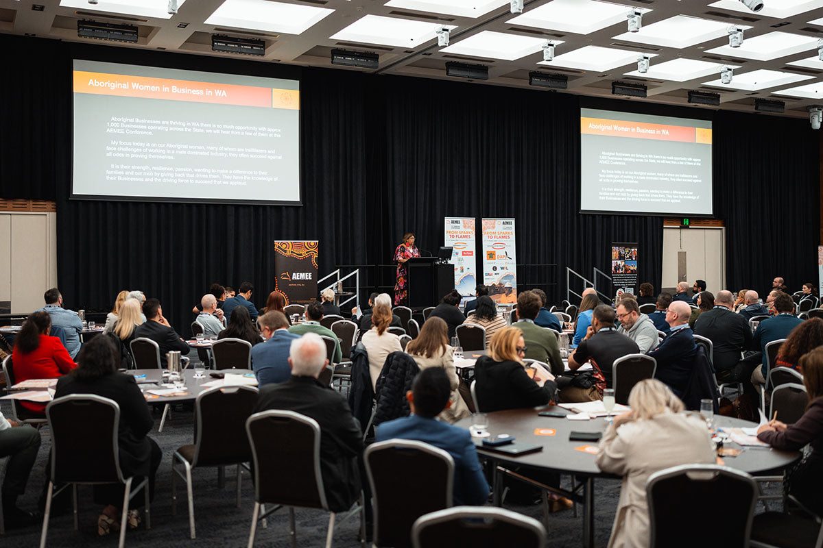 A large crowd of corporate delegates seated at round tables in a main auditorium during a presentation on Equity & Ownership at the annual AEMEE conference.
