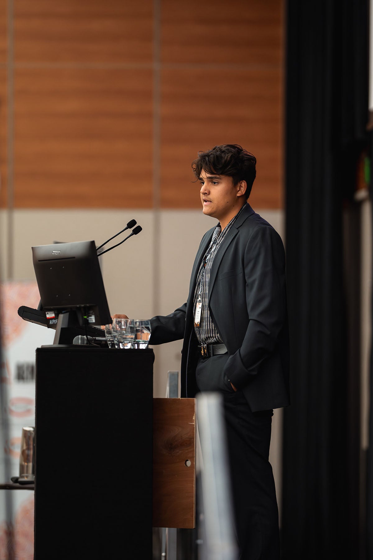 An emerging leader addressing delegates from the main stage podium during an interactive plenary panel session at the annual national AEMEE conference.