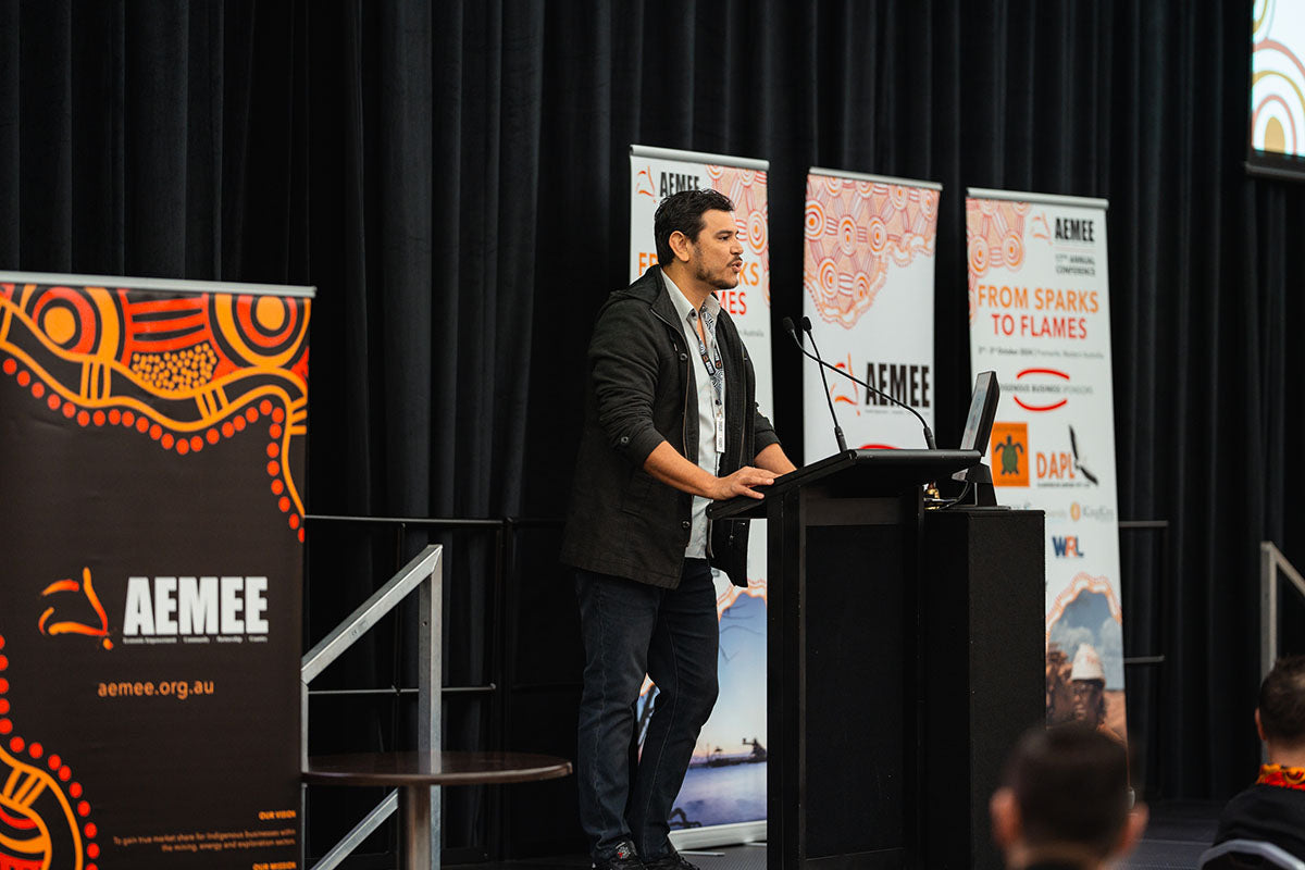 AEMEE Board Member and DICE Australia Director Raymond Pratt presenting at the main stage podium during a plenary session at the 2024 national conference.
