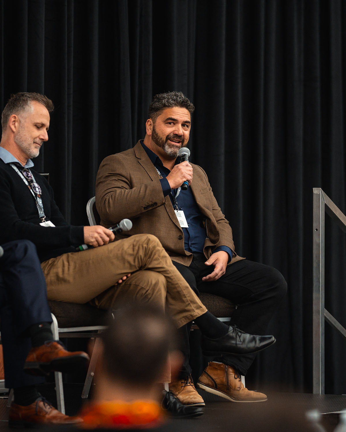 Corporate speakers discussing Tier One procurement models and community asset investment strategies from the main stage at the national AEMEE conference.