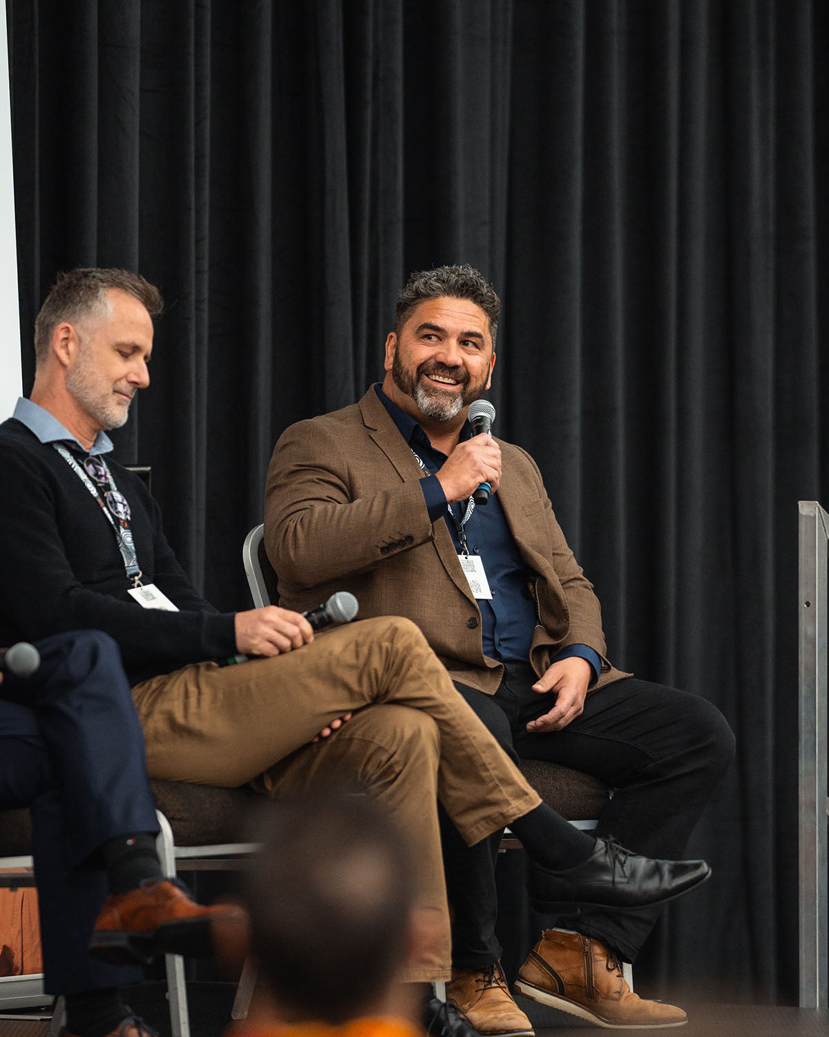 Two corporate resource partners conversing into microphones during an interactive technical stream panel at the annual AEMEE conference.