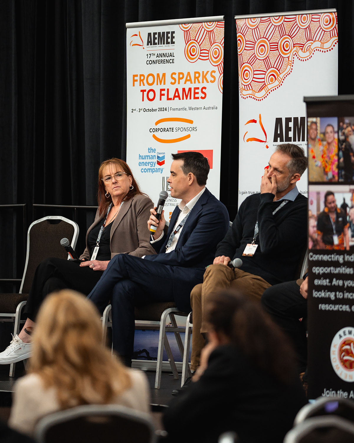 Matt Plichta addressing the audience into a microphone during a collaborative plenary panel focused on long-term sustainability frameworks in the resource sector.