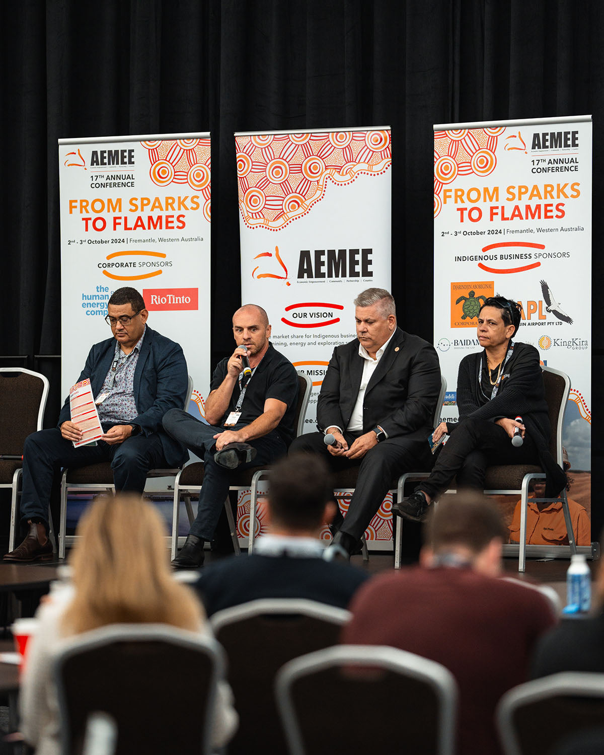 A male panelist addressing delegates via microphone during an interactive stream focused on commercial pathways in the Indigenous business resources sector.