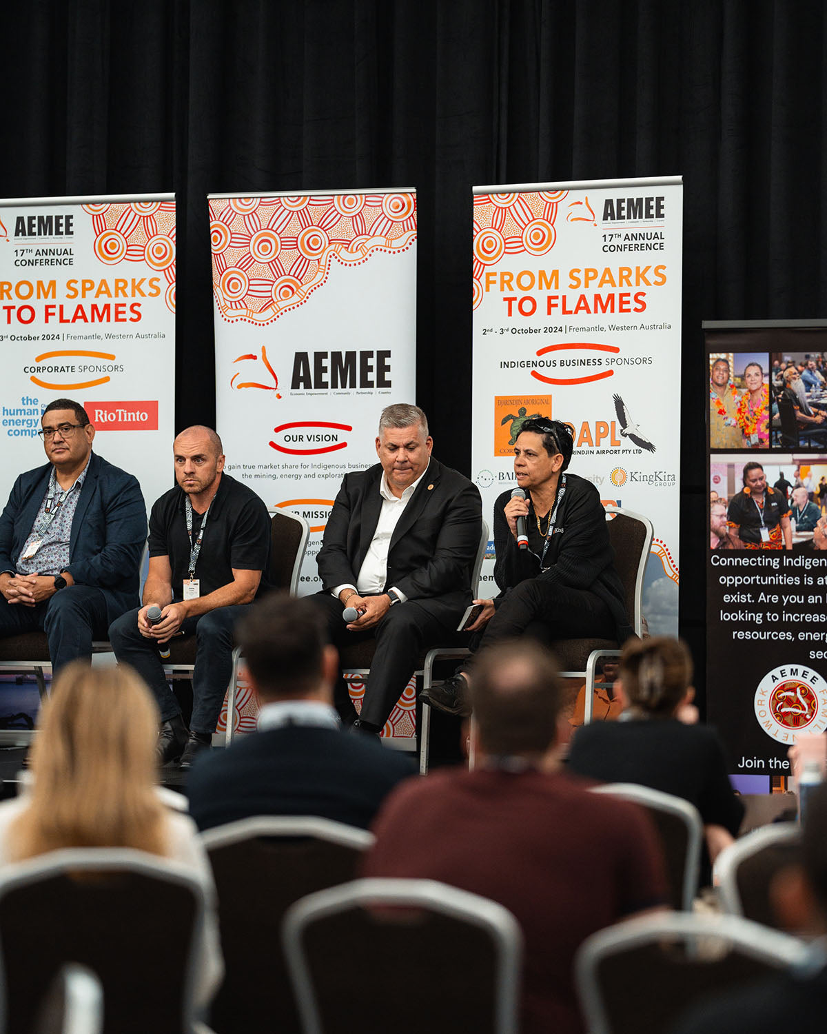 AEMEE Board Member and Kingkira Group Founder Tammy O'Connor speaking into a microphone while seated on an interactive stage panel during a plenary session at the annual conference.