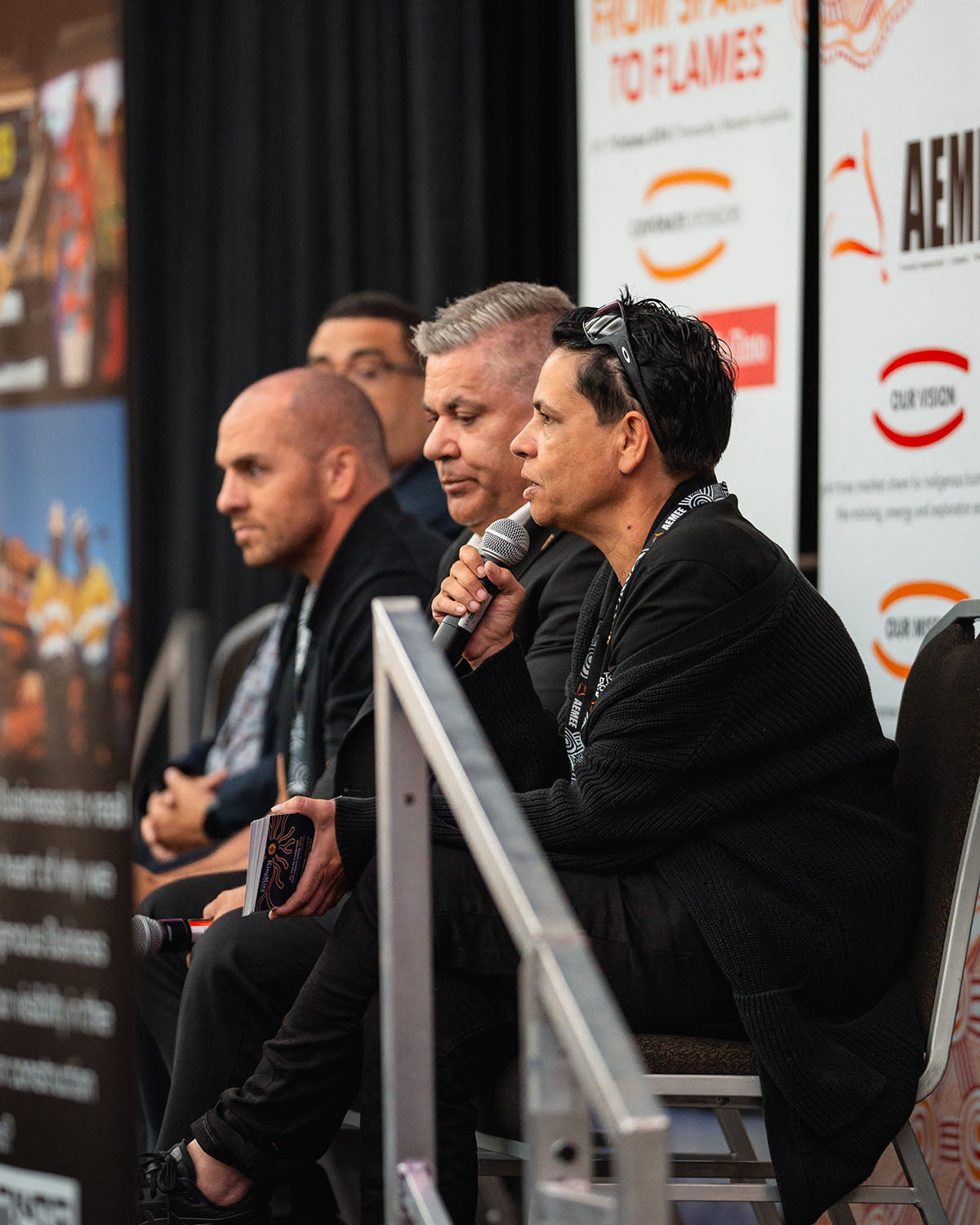 Kingkira Group Founder Tammy O'Connor addressing audience delegates into a microphone from her panel seat on the main stage at the national AEMEE conference.