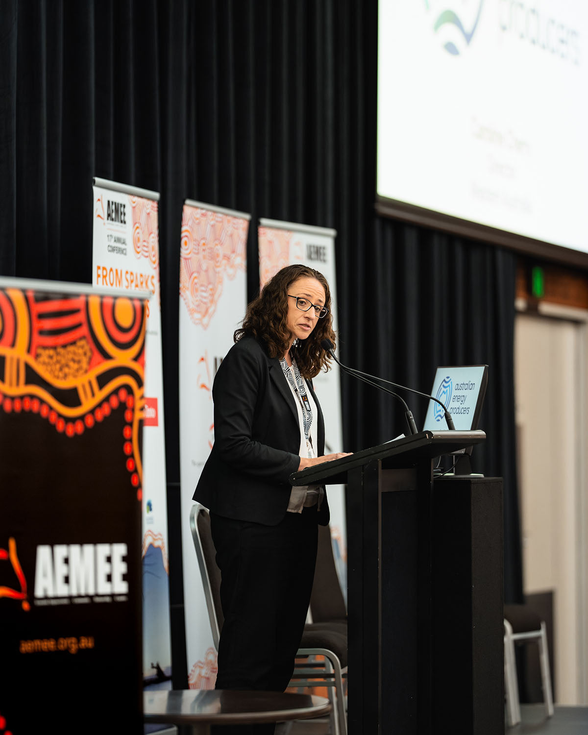 Presenter Caroline Cherry speaking from the main stage podium on the crucial role of gas in delivering economic and energy security at the national AEMEE conference.
