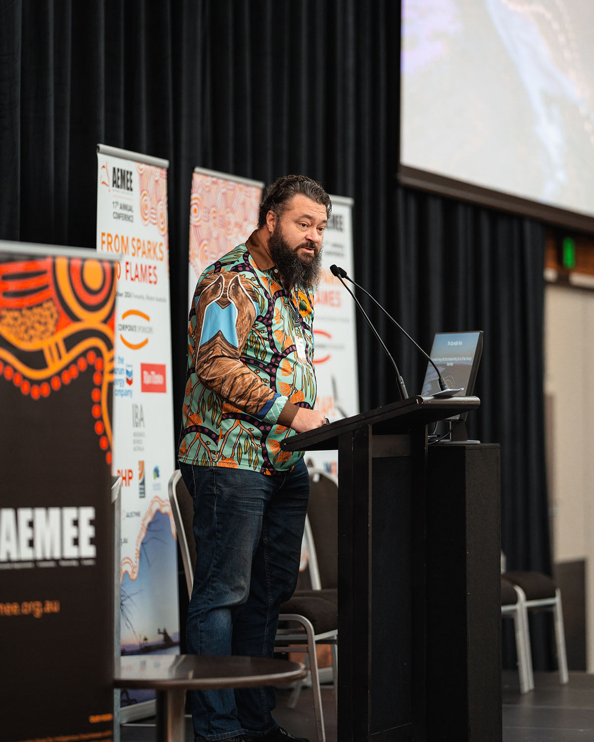 Nathan McIvor speaking at the stage microphone about renewable energy and Net Zero emission policy frameworks within the Indigenous business resources sector.