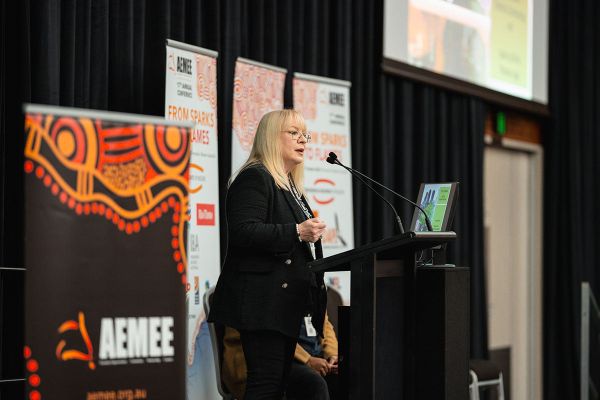 Thomas Legal representative Sabina Schlink presenting on legal and corporate frameworks from behind the microphone at the 17th Annual AEMEE conference.
