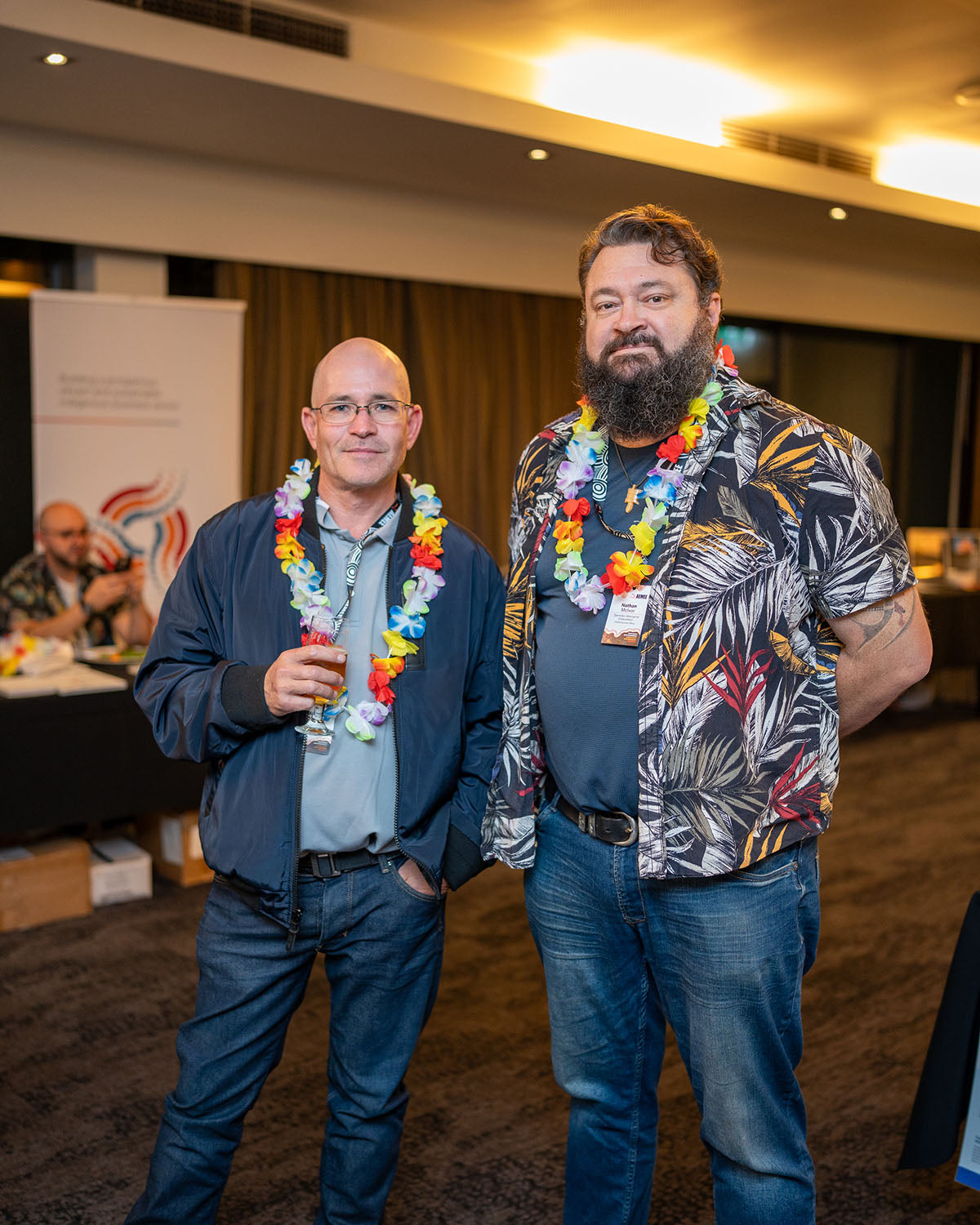 Nathan McIvor, CEO of Djarindjin, standing with another conference presenter wearing decorative floral leis to showcase community enterprise success.