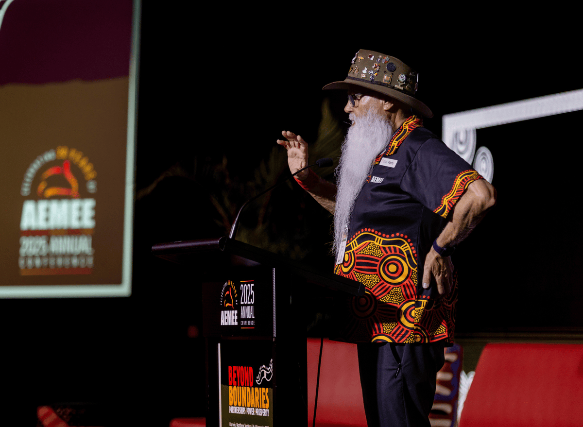 Indigenous Elder speaking at the podium at the AEMEE 2025 Annual Conference Day 1 — Beyond Boundaries session, Darwin
