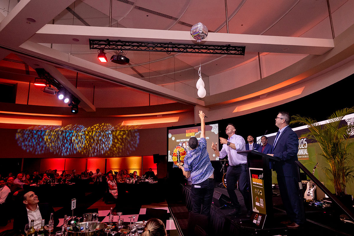 Award recipient celebrating on stage during the National AEMEE Awards ceremony.
