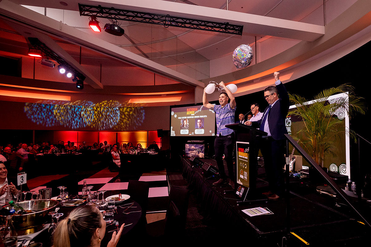 National AEMEE Awards recipient celebrating on stage with presenters during the 2025 Annual Conference.