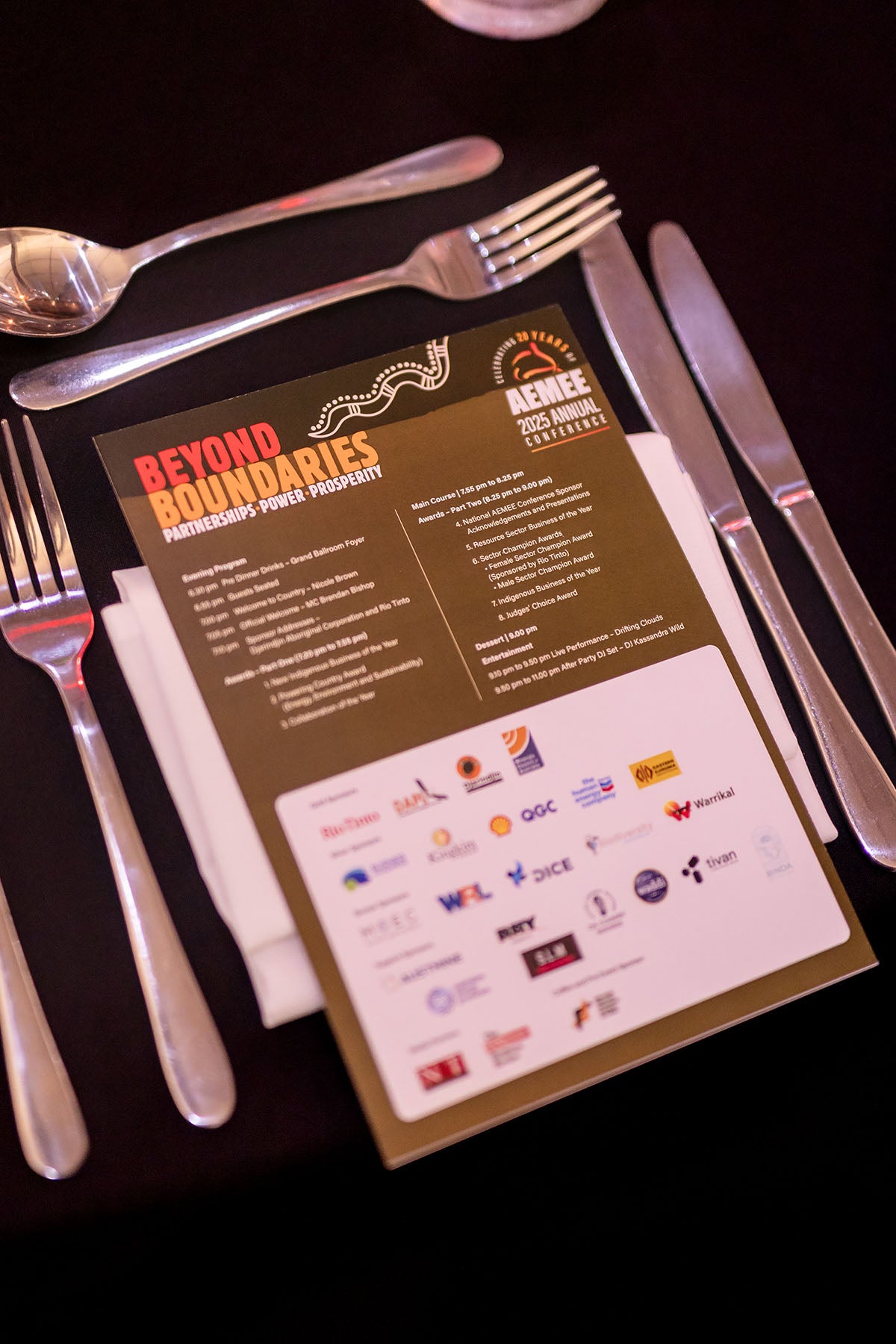 Gala dinner place setting with AEMEE 2025 Beyond Boundaries conference program, Darwin