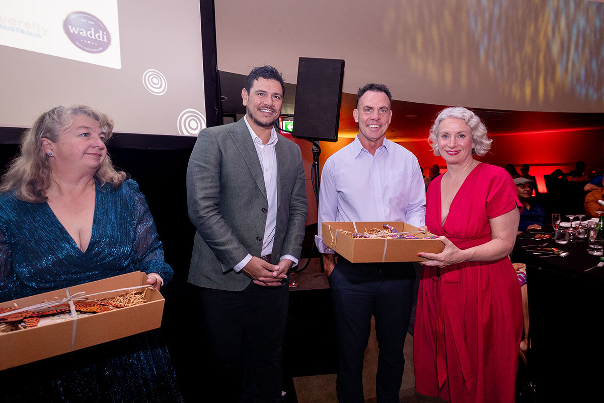 AEMEE conference guests posing with a gift box during the 2025 Annual Conference awards dinner.