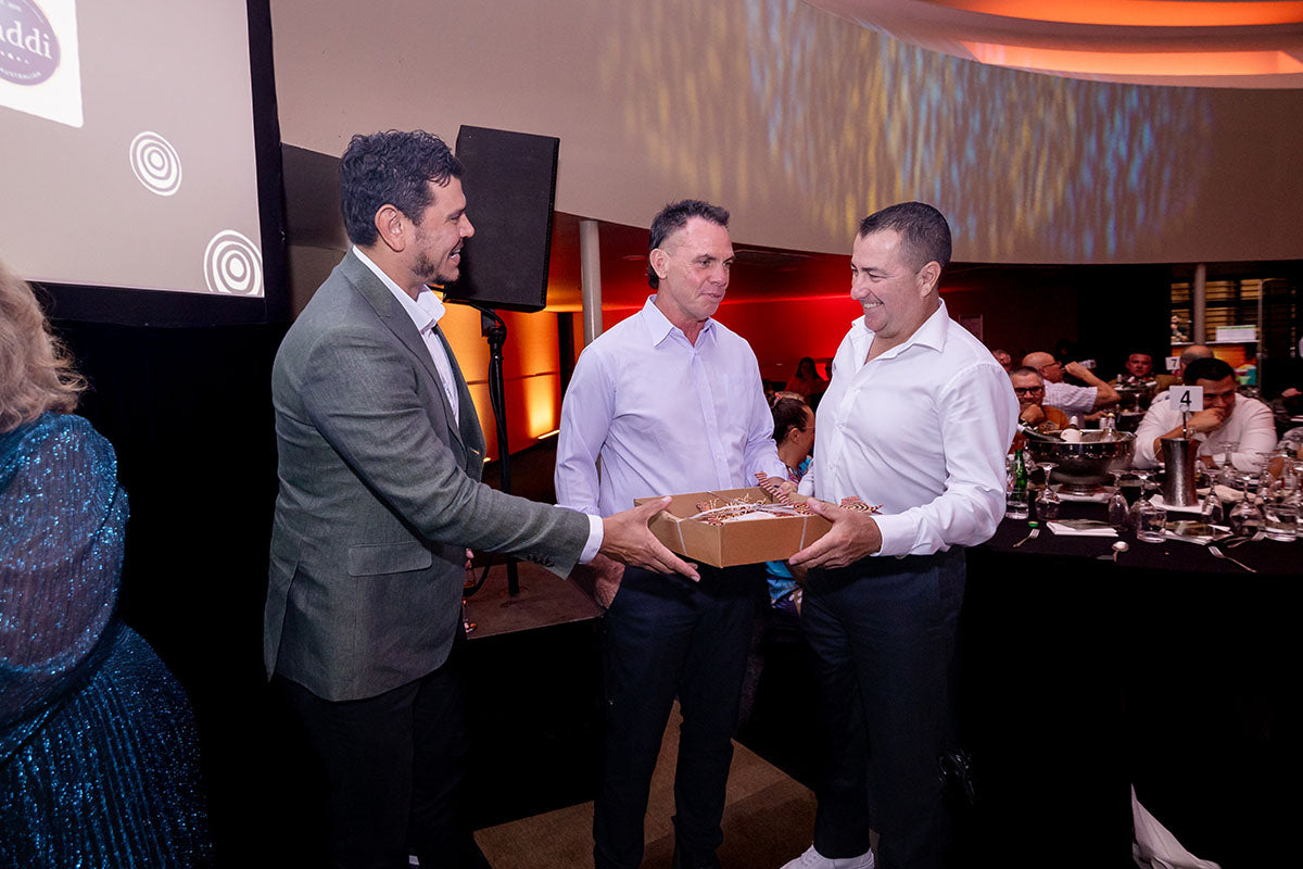 AEMEE conference presenter handing a gift box to a guest during the awards dinner.