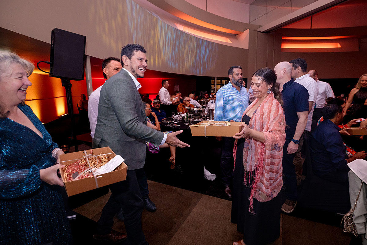 AEMEE conference presenters giving gift boxes to guests during the 2025 Annual Conference.