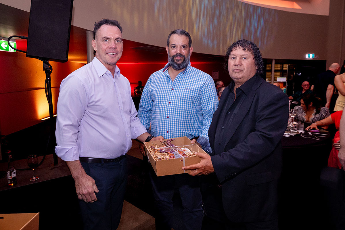 AEMEE conference guests posing with a gift box during the 2025 Annual Conference awards dinner.