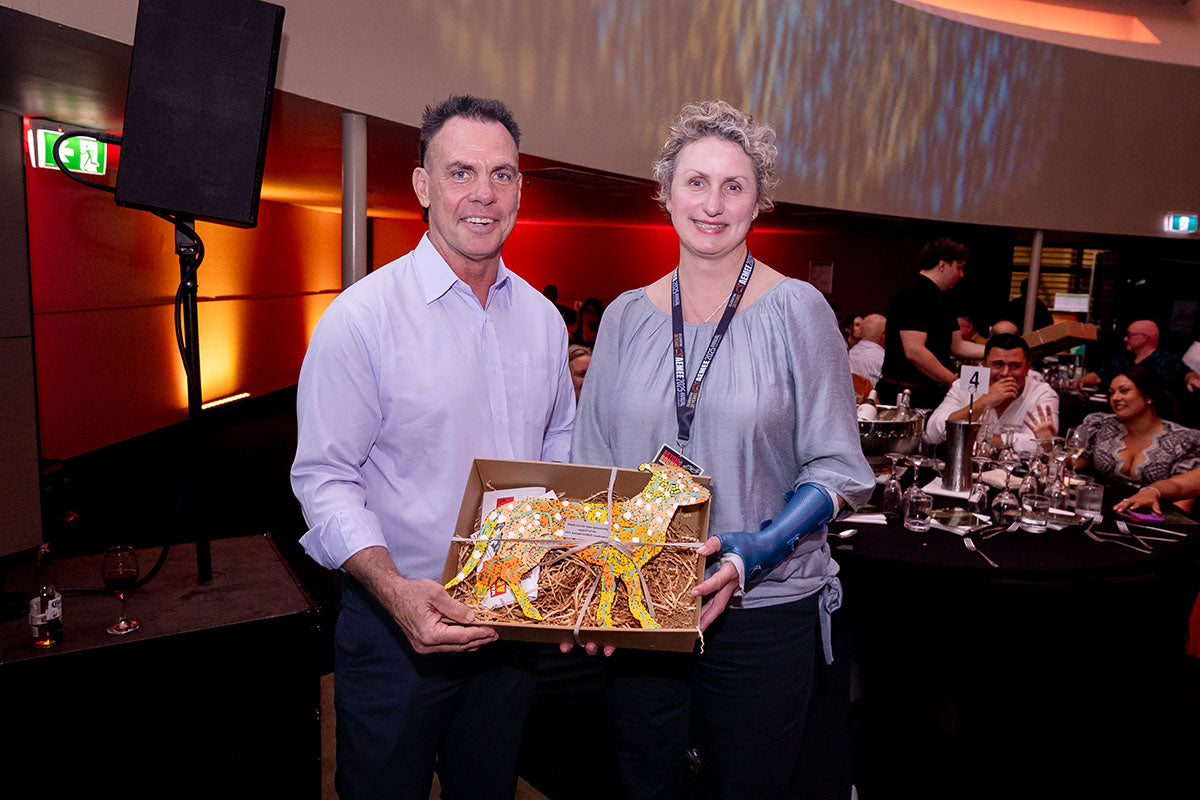 AEMEE conference guest holding a gift box during the awards dinner.