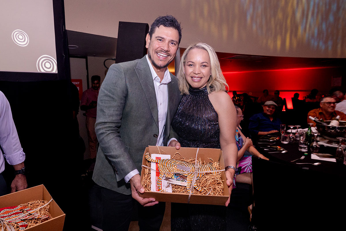 AEMEE conference guest posing with a gift box during the awards dinner.