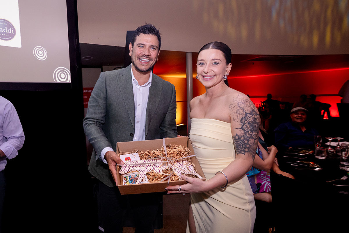 AEMEE conference guest holding a gift box during the 2025 Annual Conference awards dinner.