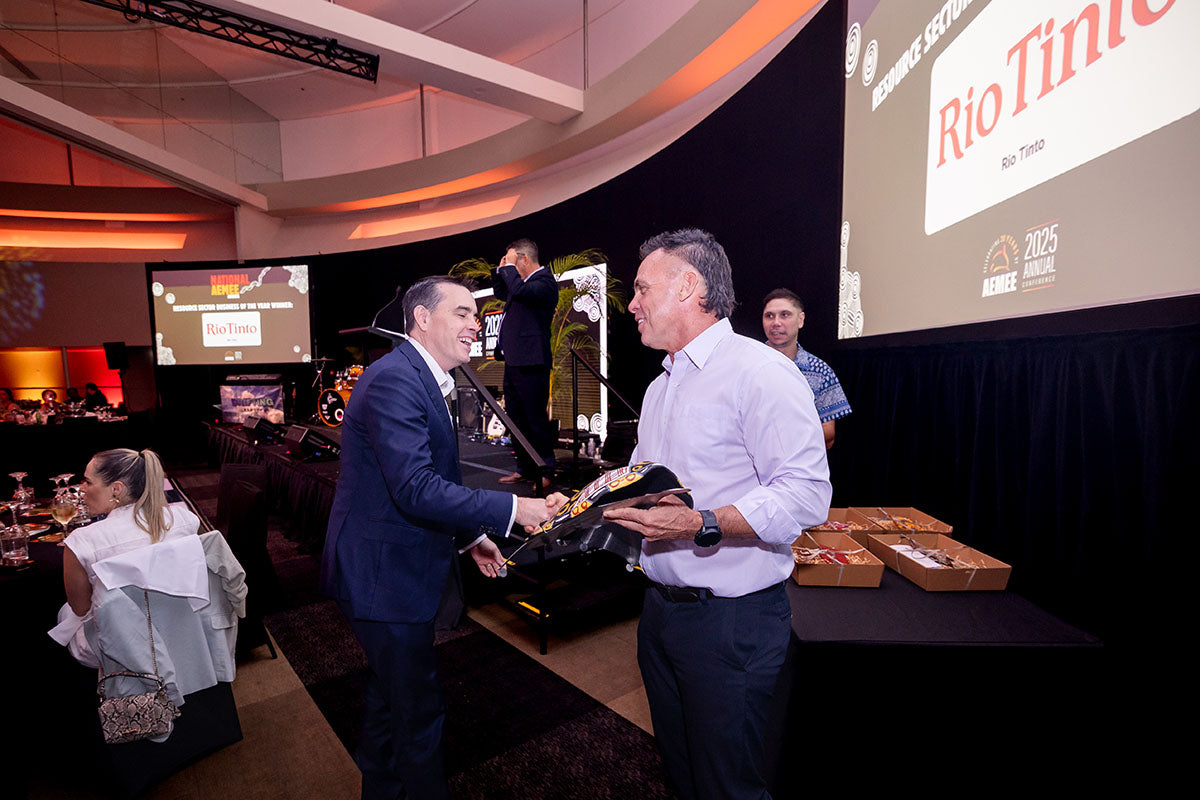AEMEE conference presenter handing a gift box to a guest during the 2025 Annual Conference awards dinner.