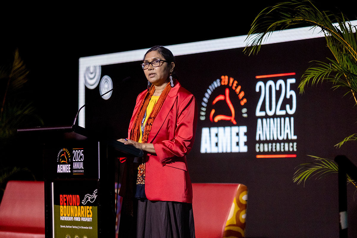 Presenter speaking at the AEMEE 2025 Annual Conference with event branding displayed behind her.