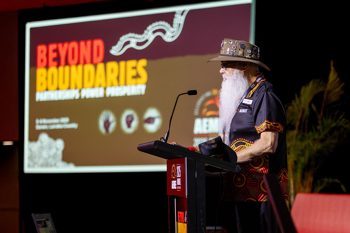 Indigenous Elder speaking at the podium at the AEMEE 2025 Annual Conference Day 1 — Beyond Boundaries session, Darwin