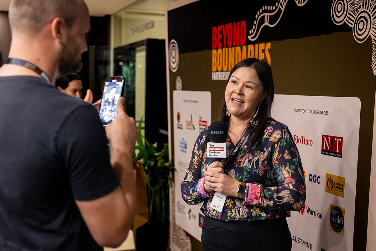 Speaker being interviewed at the AEMEE 2025 Annual Conference sponsor media wall.