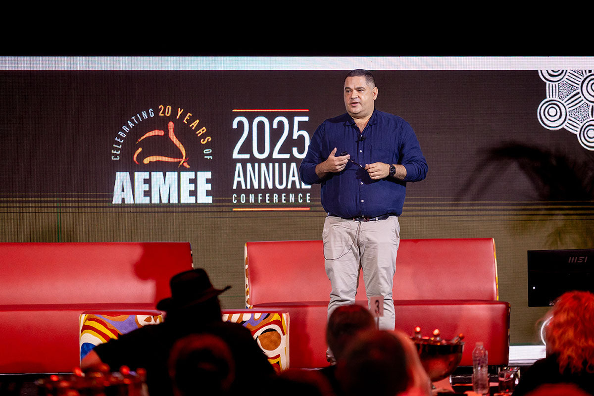 Speaker presenting on stage at the AEMEE 2025 Annual Conference.