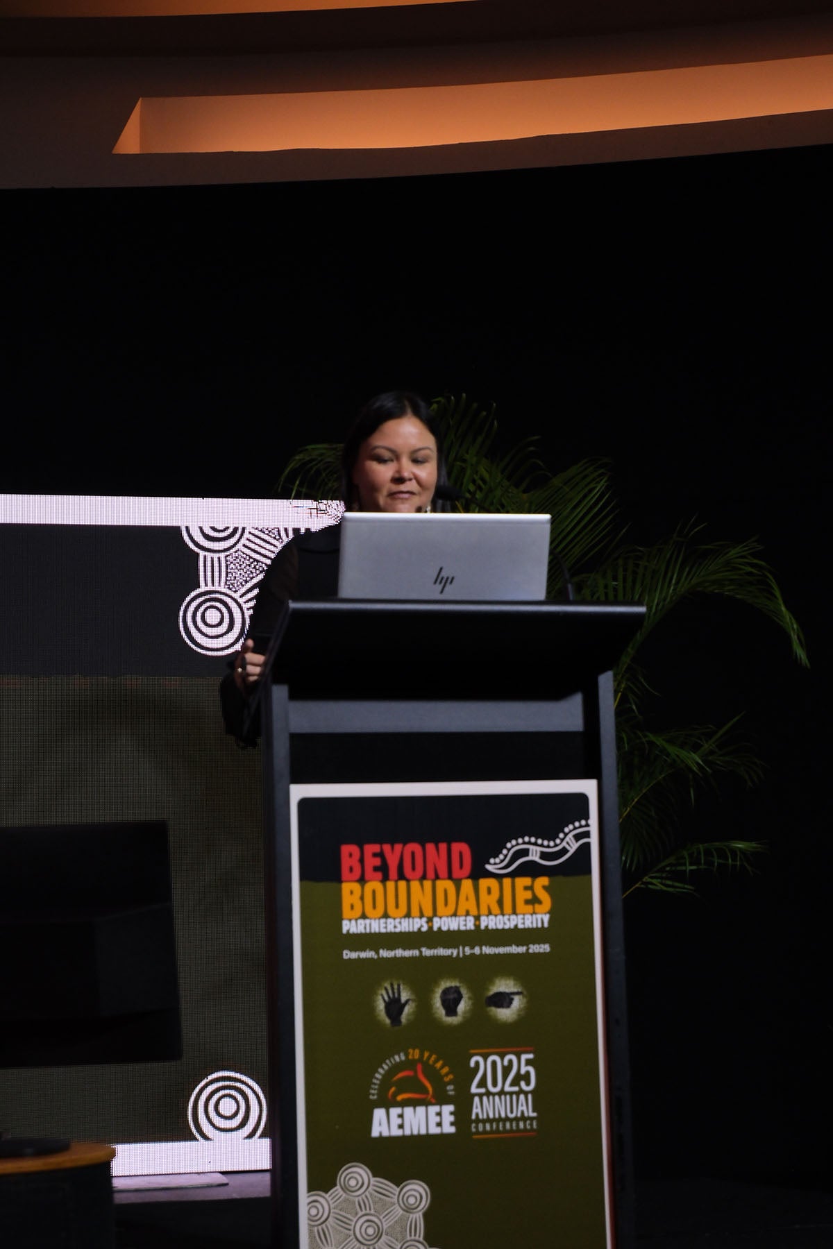 Presenter speaking from the podium at the AEMEE conference during a Beyond Boundaries session.