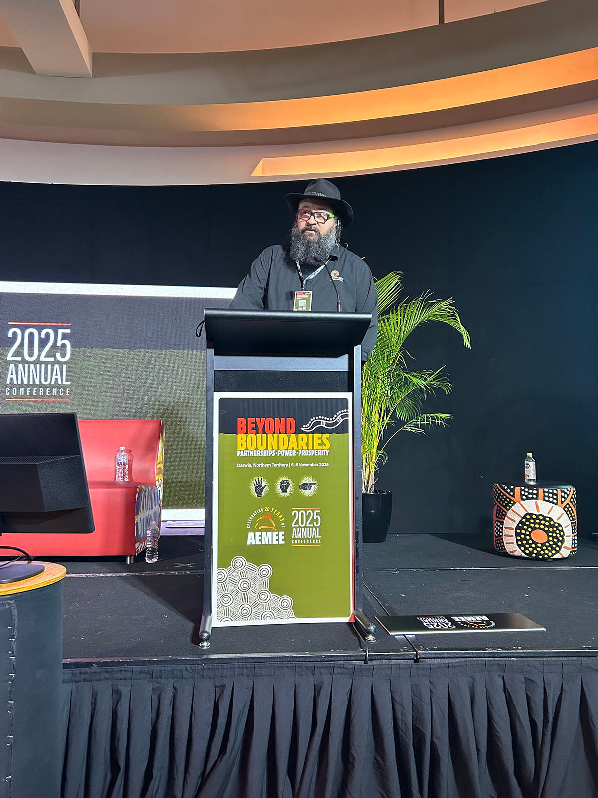 Speaker presenting at the AEMEE 2025 Annual Conference podium during a Beyond Boundaries session.