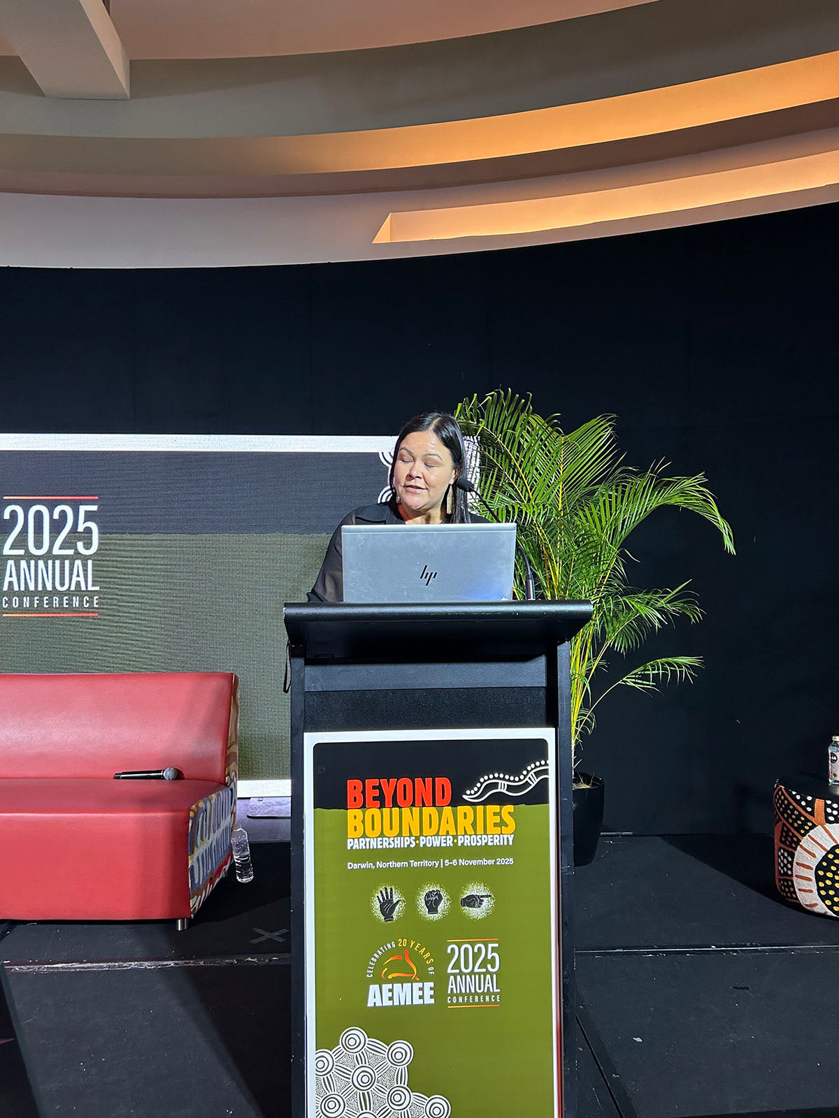 Speaker presenting from the podium during an AEMEE conference session.