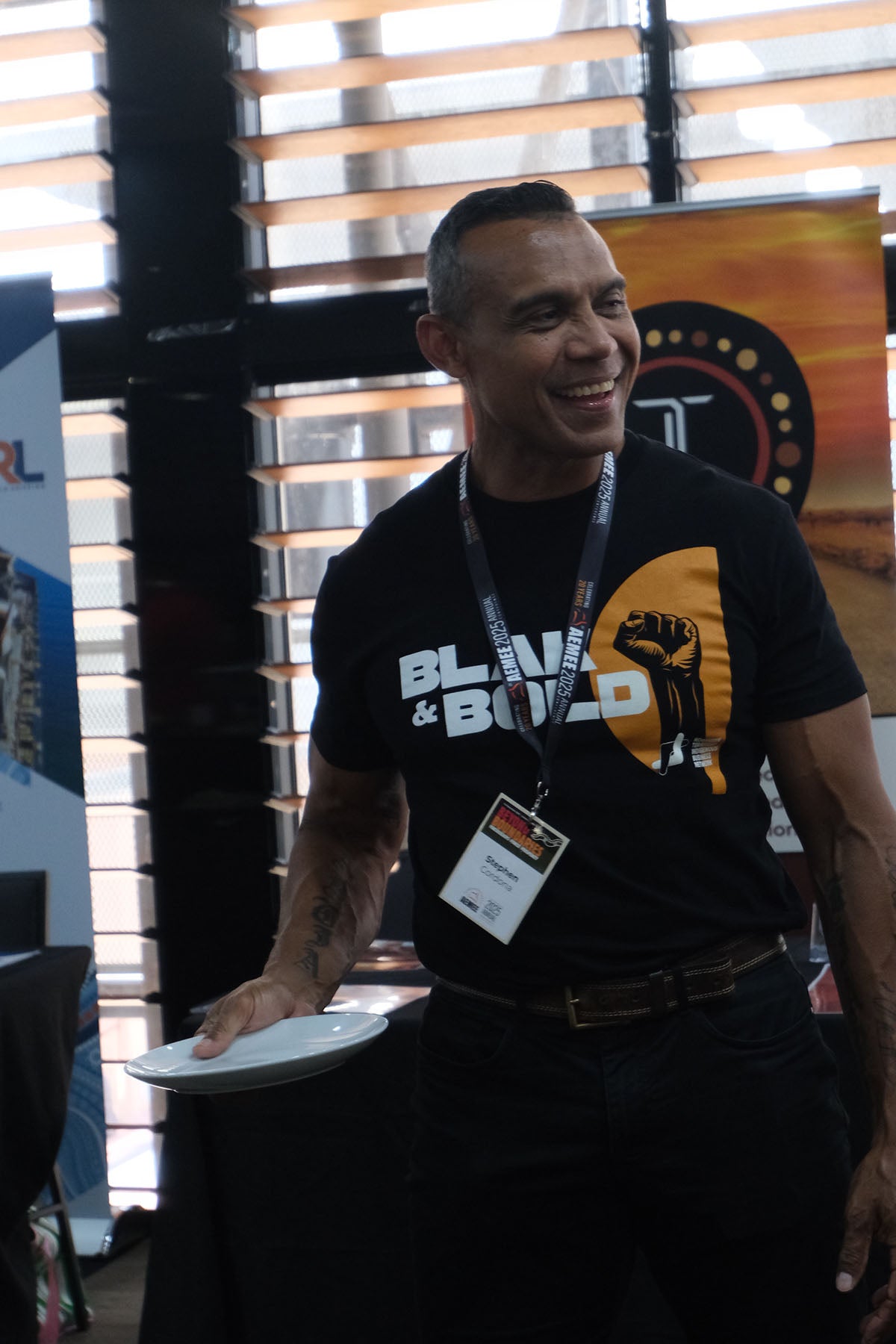 AEMEE conference attendee wearing a Black & Bold shirt during a networking session.