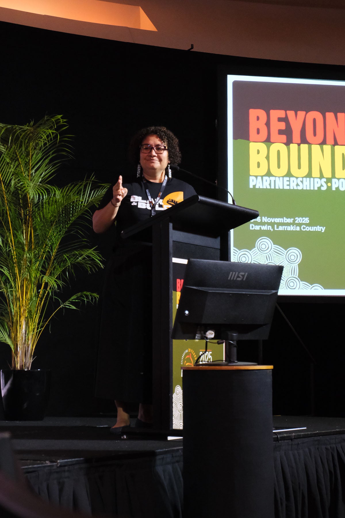 Speaker presenting from the podium at the AEMEE conference during a Beyond Boundaries session.
