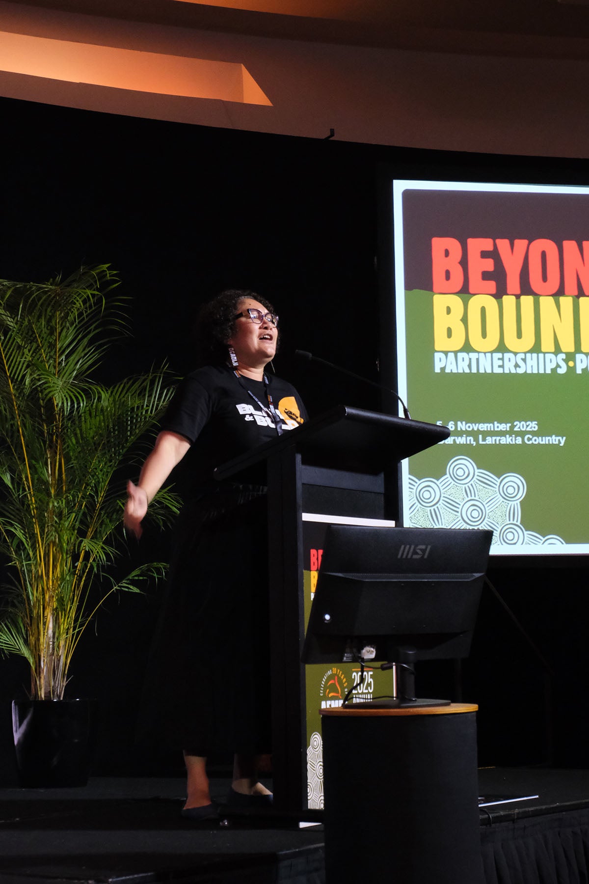 Presenter speaking with delegates during an AEMEE conference session on Indigenous business and sector collaboration.