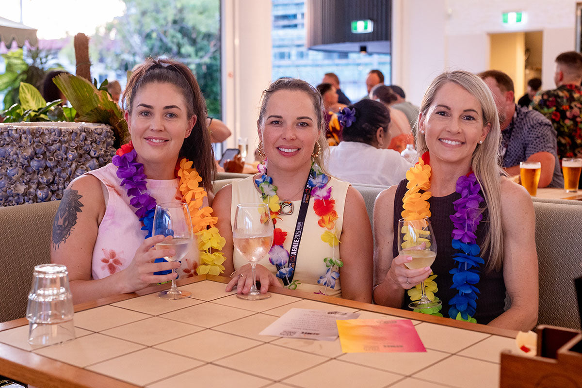 Delegates enjoying the AEMEE 2025 Annual Conference networking night in Darwin, wearing Hawaiian leis