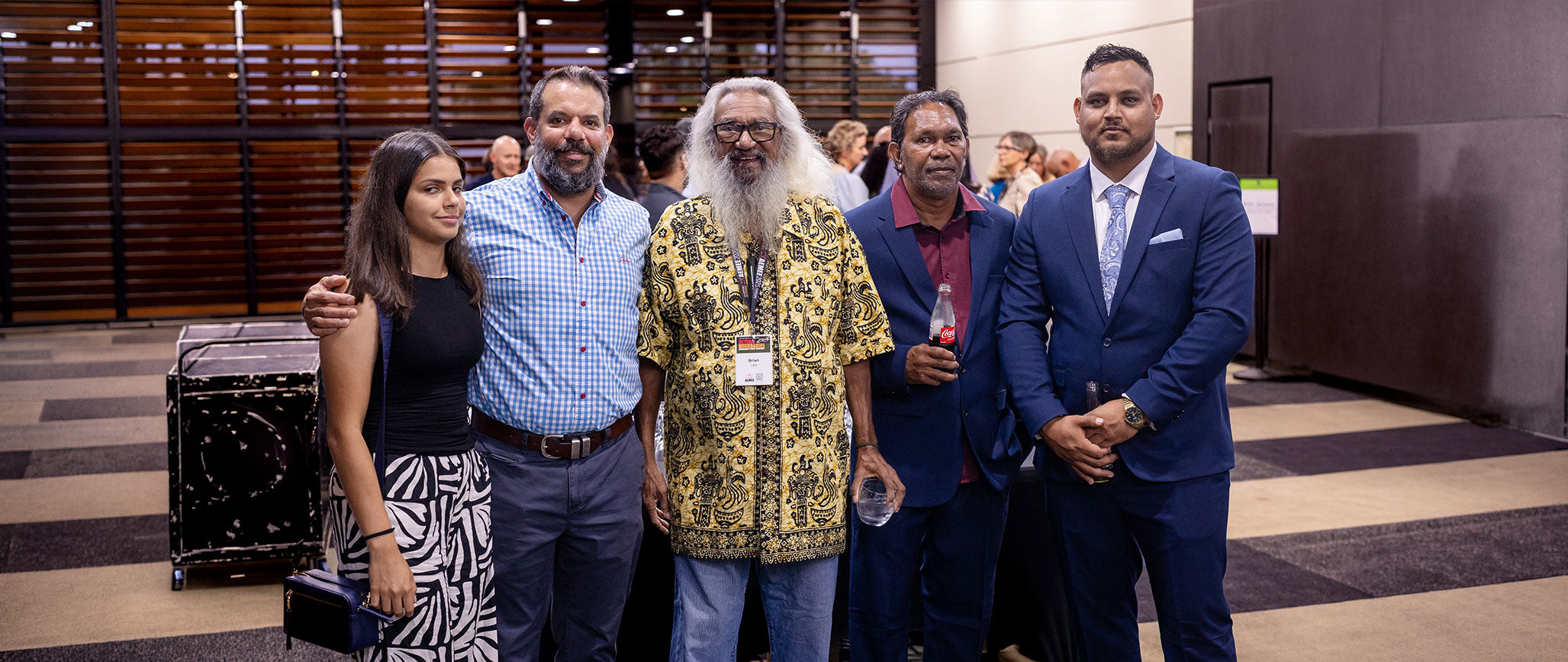 A group of five AEMEE network members, including Chief Executive Jyi Lawton and a prominent community Elder, standing together at a national conference gathering.
